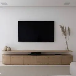 میز تلویزیون یکی از عناصر کلیدی در دکوراسیون اتاق نشیمن یا اتاق خانواده است. اگر به دنبال ایجاد فضایی مدرن و در عین حال گرم و دعوت کننده هستید، انتخاب یک میز تلویزیون چوبی مدرن می تواند گزینه ای ایده آل باشد. میز تی وی چوبی مدرن با خطوط تمیز و ساده خود، زیبایی طبیعی چوب را به نمایش می گذارد و در عین حال ظاهری شیک و معاصر ارائه می دهد. این نوع میز تلویزیون می تواند به راحتی با سایر عناصر دکوراسیون منزل شما ترکیب شود و نقطه کانونی جذابی برای اتاق ایجاد کند. هنگام انتخاب یک میز تلویزیون چوبی مدرن، گزینه های مختلفی در اختیار دارید. می توانید از بین انواع چوب های سخت یا نرم مانند بلوط، گردو، چوب ماهاگونی و یا حتی چوب های بازیافتی انتخاب کنید. همچنین، طراحی های متنوعی وجود دارند که می توانند نیازهای ذخیره سازی شما را برآورده سازند، از جمله قفسه های باز، کابینت ها و کشوها. یکی دیگر از مزایای انتخاب یک میز تلویزیون چوبی مدرن این است که می توانید آن را با سایر مبلمان چوبی در اتاق هماهنگ کنید. این امر یکپارچگی و هارمونی را در دکوراسیون فضای شما ایجاد می کند و اتاقی آرامش بخش و خوشایند را به وجود می آورد که می توانید در آن استراحت کنید و از زمان خود لذت ببرید.