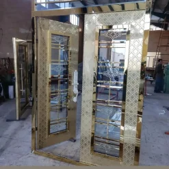 درب استیل طلایی طرح‌دار با شیشه حکاکی‌شده | درب ورودی لوکس ضد زنگ